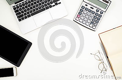 Electronic devices placed on white desks. there are computers, phones, tablets, glasses, notebooks, pencils. There is space for Stock Photo