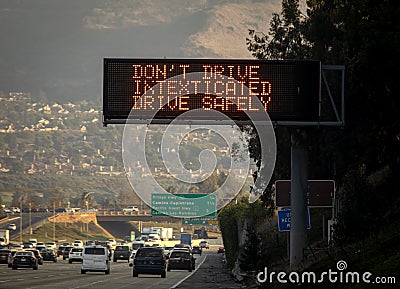 An electronic freeway sign advising against texting while driving. Stock Photo