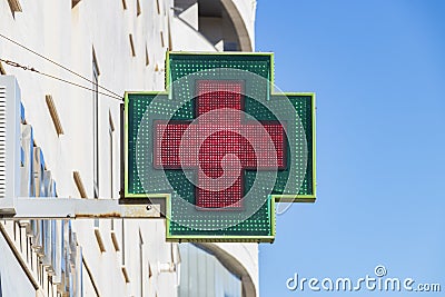 Electronic green and red cross outside a pharmacy Editorial Stock Photo