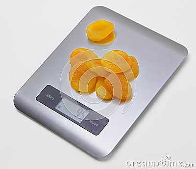 Electronic kitchen scale with dried apricots Stock Photo