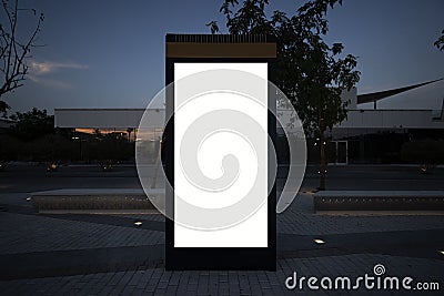 Electronic modern empty scoreboard on the background of a city street in the evening. Blank mock up of vertical street Stock Photo