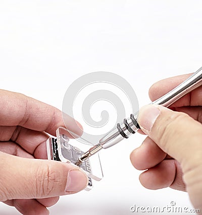 Electronic technician removing metal nut with a precision screwdriver Stock Photo
