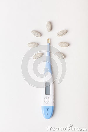 Thermometer with pills around it Stock Photo