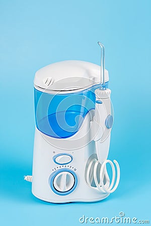 Electronic Tooth Irrigator for personal home usage on blue background Stock Photo