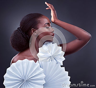 Elegance is beauty that never fades. Studio shot of a beautiful young woman posing with origami fans against a black Stock Photo