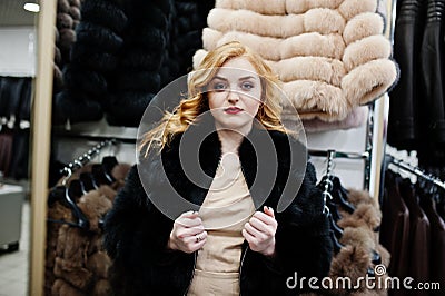 Elegance blonde girl in fur coat store Stock Photo