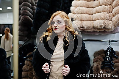 Elegance blonde girl in fur coat store Stock Photo