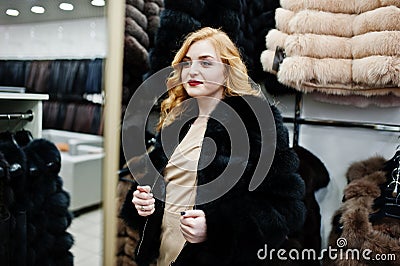 Elegance blonde girl in fur coat store Stock Photo