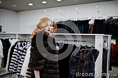 Elegance blonde girl in fur coat store Stock Photo