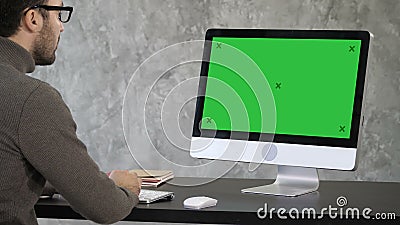 Elegant affärsman som i regeringsställning analyserar data på hans dator Tillbaka sikt till bildskärmen Grön skärmmodellskärm lager videofilmer Elegant affärsman som i regeringsställning analyserar data på hans dator Tillbaka sikt till bildskärmen Grön skärmmodellskärm lager videofilmer