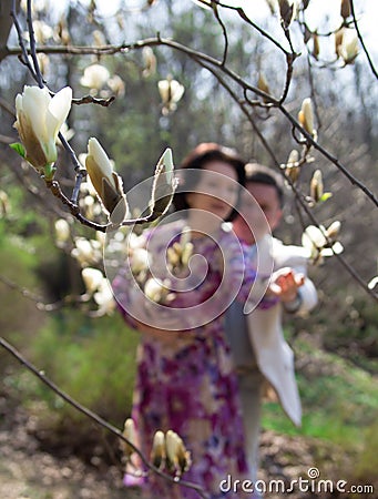 Adult couple walks in the blossoming magnolia garden. True love. Stock Photo