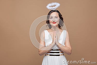 Elegant angel brunette woman in white dress and nimbus in top of Stock Photo