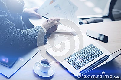 Elegant banking finance analyst working at sunny office on laptop while sitting at wooden table.Businessman analyze Stock Photo