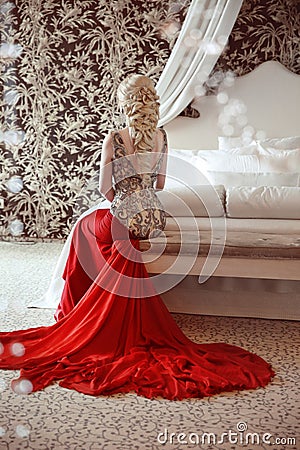 Elegant blond woman model wearing in luxurious red gown with lo Stock Photo