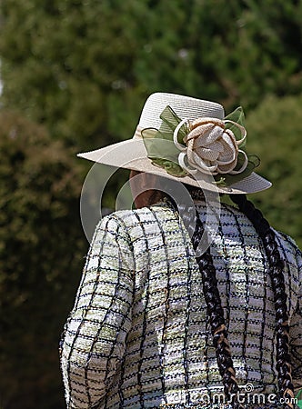 Elegant Bolivian woman with two braids wearing a fancy flower hat and a woven sweter with square pattern Editorial Stock Photo