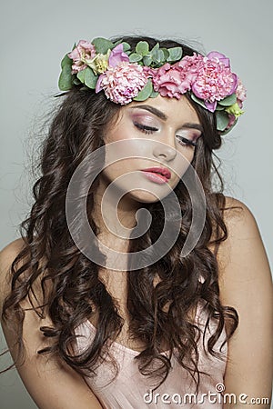 Elegant brunette woman with fresh flower on her head. Spring, cosmetic, beauty, skin care and hair care concept Stock Photo
