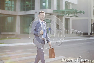 Elegant businessman in blue suit walking out of bank Stock Photo