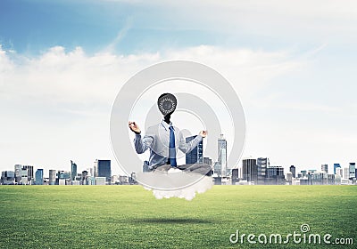 Camera headed man sitting in lotus pose on cloud against modern Stock Photo