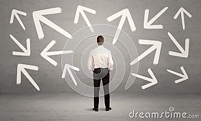 Confused salesman with arrows on wall Stock Photo