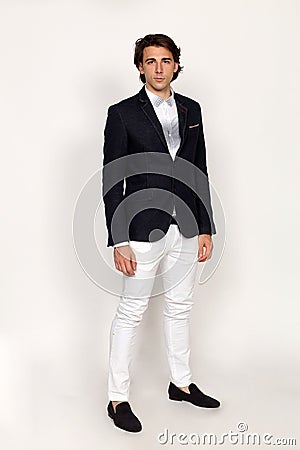 Elegant, charismatic young man is posing in studio on isolated background. Trends, success, business concept. Stock Photo