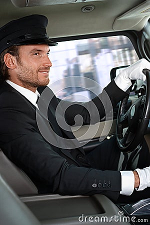 Elegant chauffeur driving luxurious car Stock Photo