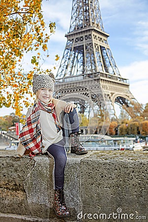 Elegant child on embankment in Paris sitting on the parapet Stock Photo