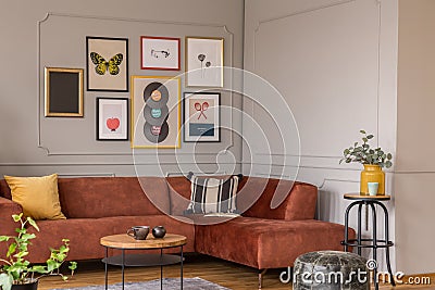 Elegant coffee table in front trendy sofa in living room interior with grey wall Editorial Stock Photo