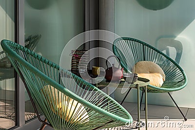Elegant corner of a terrace of a modern house with two armchairs and a Chinese tea with two cups Stock Photo