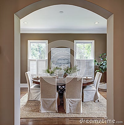Elegant dining room through curved arch doorway Stock Photo