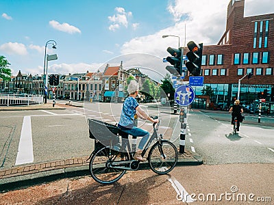 Elegant Dutch woman riding a Bike green light Editorial Stock Photo