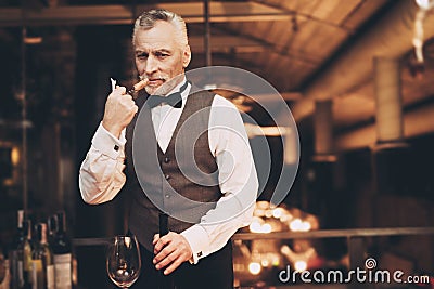 Elegant experienced sommelier uncorking bottle of wine in restaurant. Wine tasting. Stock Photo