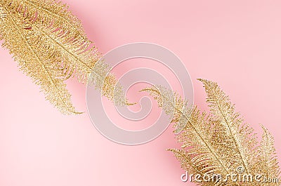 Elegant exquisite travel background - golden glittering sparkling fern branches on pastel pink background as decorative border. Stock Photo