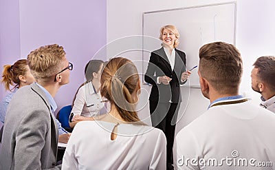Female teacher lecturing to students at auditorium Stock Photo