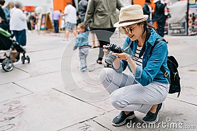 An elegant female traveler crouch on the street Stock Photo