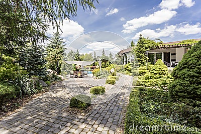 Elegant garden with the paved path Stock Photo