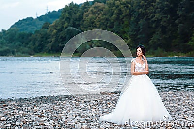 Elegant gentle stylish bride near river or lake. Wedding couple in love Stock Photo