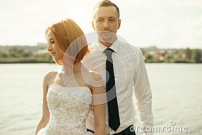 Elegant gentle stylish groom and bride near river or lake. Wedding couple in love Stock Photo