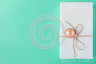 Elegant Gift Box Wrapped in White Paper Tied with Twine Pink Bauble Hanging. Christmas Presents Shopping Sale Stock Photo