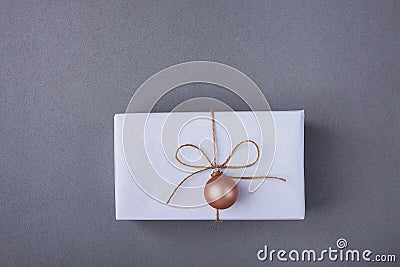 Elegant Gift Box Wrapped in White Paper Tied with Twine Pink Christmas Tree Ball Hanging. New Years Presents Shopping Sale Stock Photo