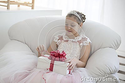 Elegant girl opens a gift. Stock Photo