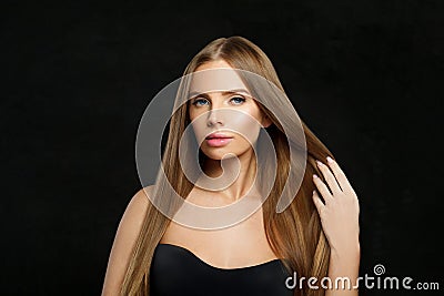 Elegant glamorous woman fashion model with long straight healthy hair and makeup posing on black background Stock Photo