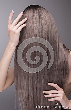 Elegant hands with nude manicure and perfect purple long hair. Stock Photo