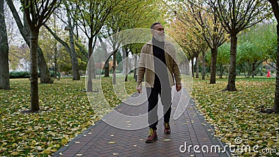 Elegant handsome man with long grey beard walking alone road in autumn park. Stock Photo