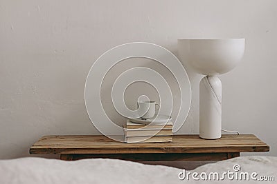 Elegant home, interior. Cup of coffee, books and modern marble geometric lamp on vintage teak wooden bench, table. Empty Stock Photo