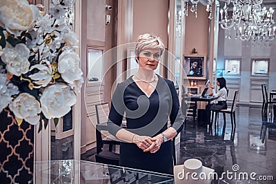 Elegant jewellery boutique`s owner is waiting for customers in her beautiful posh shop Stock Photo