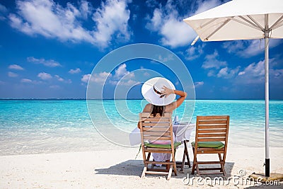 Lady enjoys her breakfast on a tropical paradise beach Stock Photo