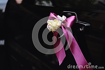 Elegant luxury black car decorated with roses and purple ribbons for a wedding Stock Photo