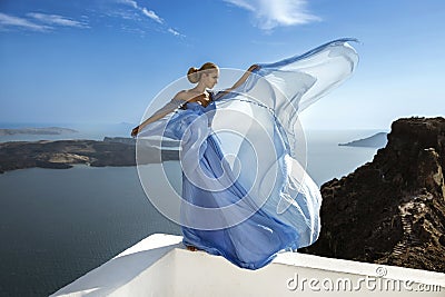 Elegant luxury evening fashion. Glamour, stylish elegant woman in long gown dress is posing outdoor in luxury resort in Santorini Stock Photo