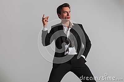 Elegant man in tuxedo snapping his fingers and blinks Stock Photo