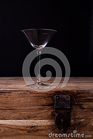 Elegant martini glass on wooden table with black wall background Stock Photo